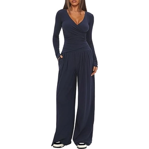 Detail of navy blue wide-leg jumpsuit with deep V-neck and slim-fit long sleeves