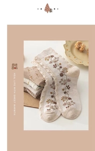 Detail of vintage beige cotton socks with floral embroidery and lace trim