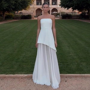 Détail d'une élégante robe blanche à épaules dénudées avec ourlet asymétrique en tulle