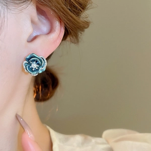 Detail of elegant blue floral stud earrings with center pearl and sparkling crystals