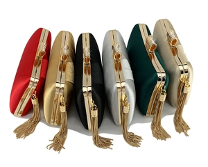 Macro detail of silk weave clutch bags with gold metal hardware and tassels