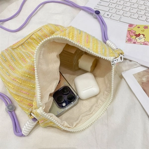 Interior view of colorful woven crossbody bag showing smartphone and perfume storage