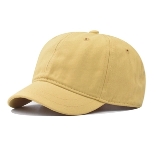 Détail d'une casquette en coton jaune gingembre avec visière courte et coutures précises