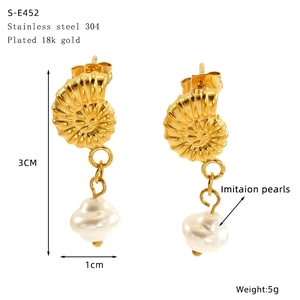Detailed view of 18K gold plated nautilus shell earrings with hanging imitation pearl