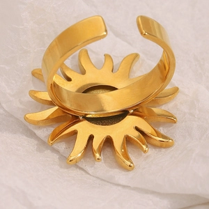 Macro shot of gold-plated sun ring with zircon stone on textured white background