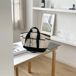 Close-up of a high-capacity canvas tote bag with multi-pocket design and contrast base