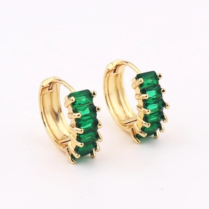 Close-up of golden hoop earrings with five claw-set rectangular green gemstones