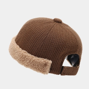 Close-up of adjustable metal buckle and warm sherpa fleece trim on a knit brimless cap