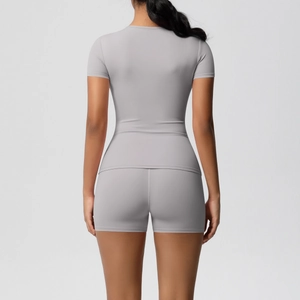 Back view of light grey slim fit yoga set featuring short sleeve top and high stretch shorts
