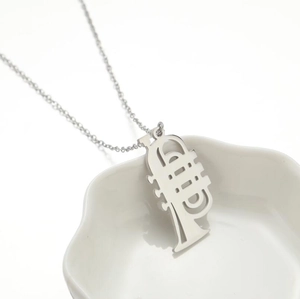 Polished stainless steel trumpet pendant necklace in a white petal dish background