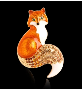 Close-up of vintage fox brooch with orange enamel and sparkling crystal rhinestones
