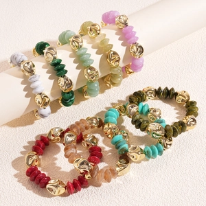Colorful acrylic beaded bracelet with irregular gold metal accents on a beige background