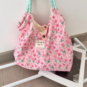 Dettaglio della borsa tote floreale rosa con trama in rilievo e manici in corda intrecciata