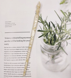 Detailed view of cream marble acetate hair stick with elegant spiral twist design
