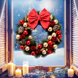 Détail d'une couronne de Noël avec roses rouges, pommes de pin dorées et nœud