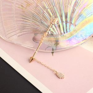 Detail of golden Hamsa hand industrial barbell with twisted arrow bar and dainty chain