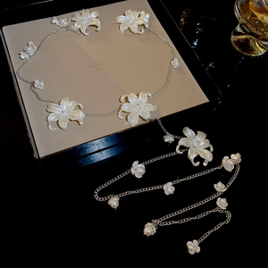 Close-up of pearl acrylic flower chain with silver metal links on a luxury jewelry box