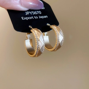 Dettaglio orecchini a cerchio a C in oro 18k con zirconi brillanti incastonati