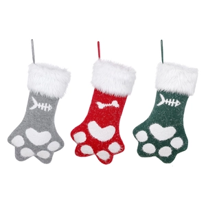 Trois chaussettes de Noël pour animaux en tricot avec empreintes de pattes, gris, rouge et vert