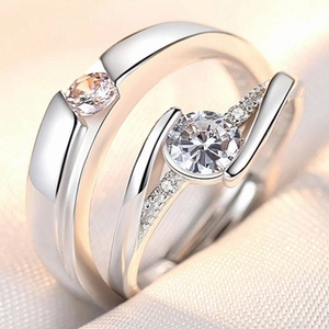 Close-up of platinum plated couple rings with adjustable bands and sparkling gemstones