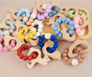Detail of baby teething bracelets with beech wood animals and colorful silicone beads