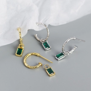 Close-up of bamboo pattern hoop earrings with detachable emerald green zircon pendants