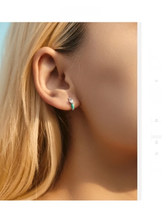 Detail of s925 silver heart earring with aqua enamel and sparkling zircon on ear
