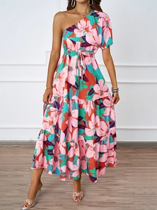 Détail d'une robe maxi fleurie rose avec épaule dénudée et lien ajustable à la taille