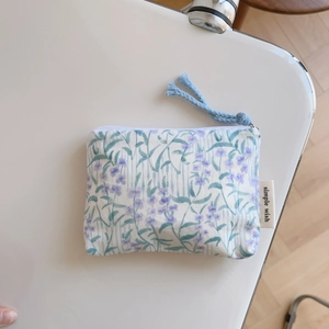 Close-up of floral cotton pouch with blue stripes and a simple wish stitched label