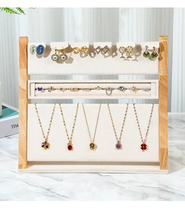 Three-tier wooden jewelry display stand with beige velvet lining for rings and necklaces