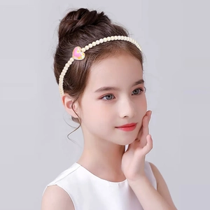 Detail of handmade pearl headband for kids featuring pink and yellow heart charms
