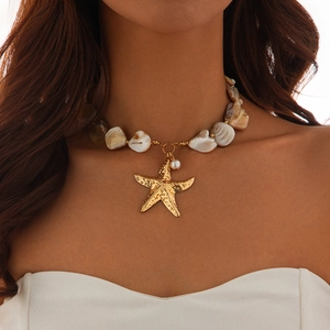 Detail of beach necklace featuring golden starfish pendant, shell beads, and a pearl