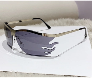Detail view of flame-shaped grey lenses with gold metal frames on a plush background