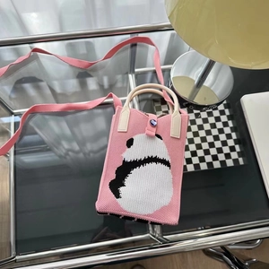 Détail du sac panda rose en maille montrant la texture douce et le décor moderne