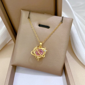Detailed view of heart-shaped pink gem necklace with starry planet ring in a gift box