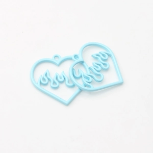 Macro shot of light blue heart pendants with hollow flame pattern for DIY jewelry