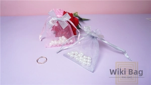 Detail view of pink organza drawstring gift bag with sparkling silver ribbon bow