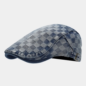 Detail of blue and white checkered denim beret featuring side metal buckle and fine stitching