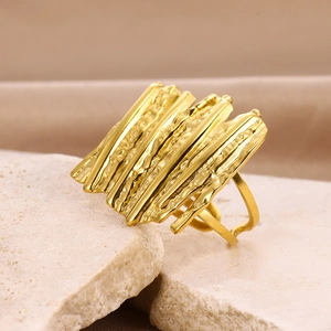 Macro shot of gold-plated wide ring with multi-layered irregular metallic textures