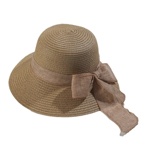 Brown woven straw sun hat for women featuring a stylish bow and UV protection for beach use