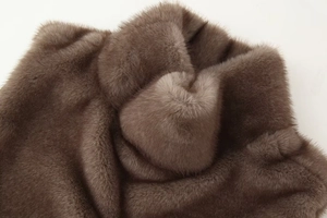 Gros plan sur la fourrure synthétique marron café montrant une texture douce et luxueuse