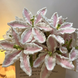 Handmade knitted lily bouquet in pink and white yarn with warm light and kraft bag