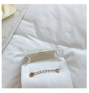 Close-up of small white silicone heart bag with gold chain and open compartment