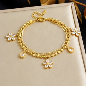 Double-layered gold-plated stainless steel bracelet with floral and teardrop crystal charms