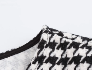 Gros plan sur le tissu en laine pied-de-poule noir et blanc sur l'épaule de la robe