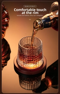 Detail of whiskey pouring into a diamond textured glass with a round cup mouth and wooden coaster