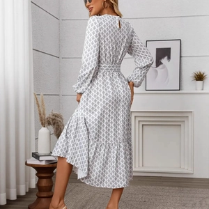 Detail of elegant white long dress featuring black geometric print and lantern sleeves