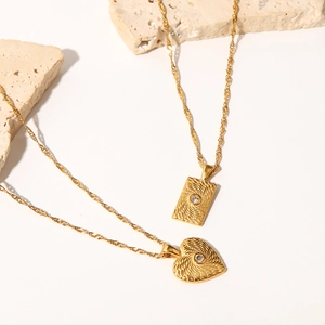 Détail de pendentifs cœur et carrés en or 18 carats avec texture soleil et zircon