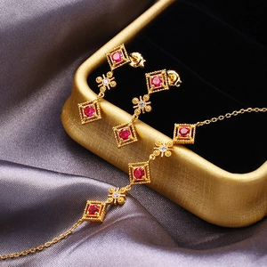 Detailansicht eines vintage Goldsets mit Halskette und Rubin-Ohrringen auf Samtbox
