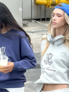 Detail of navy blue sweatshirt with Sweet Chilling embroidery in a street style setting